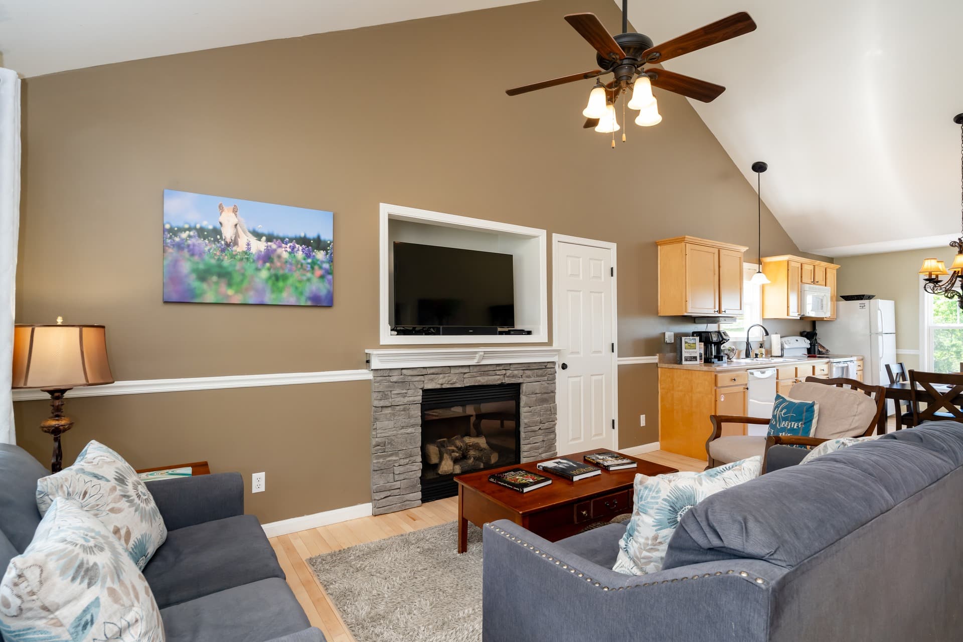 Elegant Lake Cottage in Taylorsville, Kentucky — cozy living room with propane fireplace, plush seating, and Kentucky-themed books.