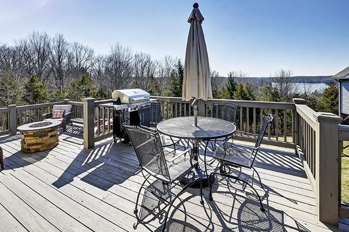 Deck dining table, grill and lake in the distance